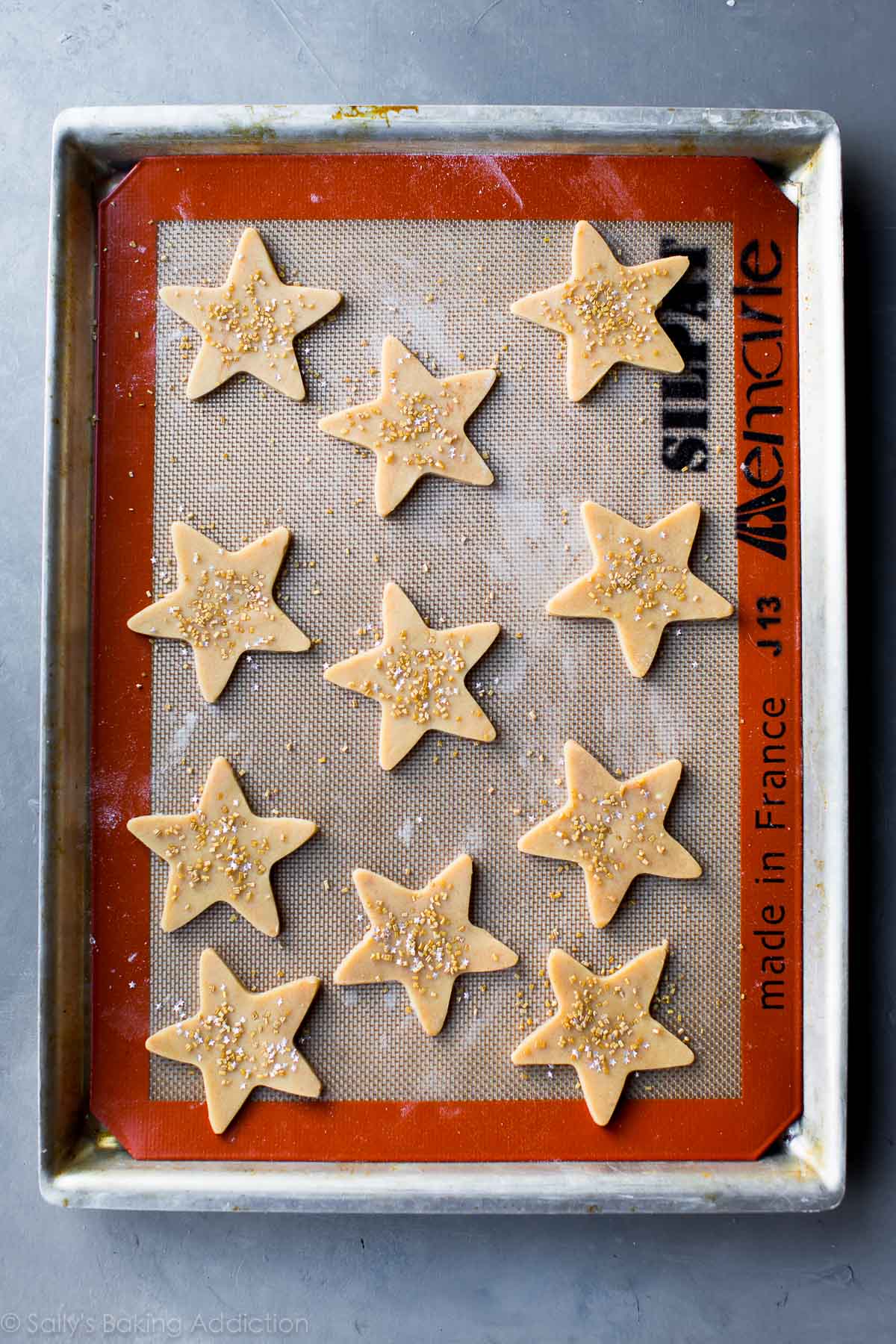 star sugar cookies with sprinkles on a baking sheet before baking