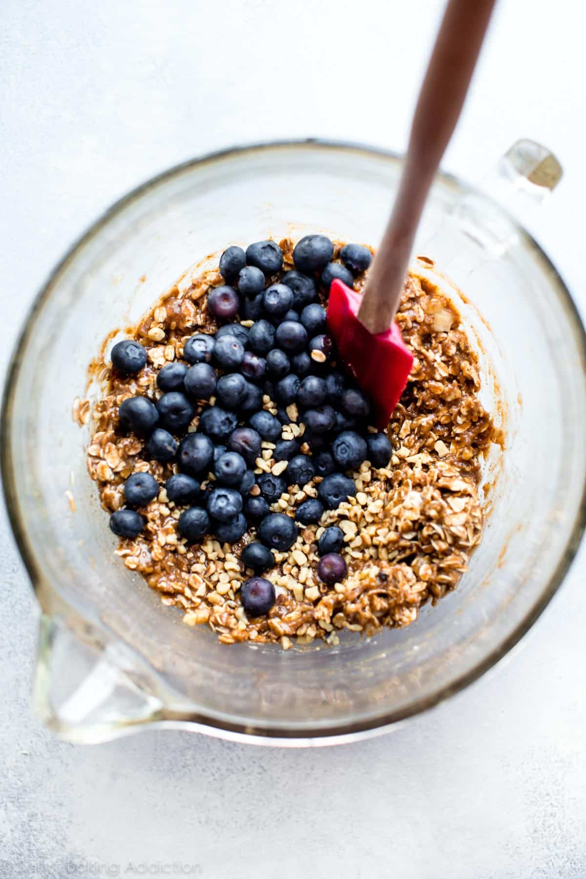 blueberry breakfast cookie dough in a glass bowl with a spatula