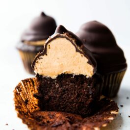 hi-hat cupcake cut in half showing chocolate cupcake topped with peanut butter frosting inside a chocolate coating