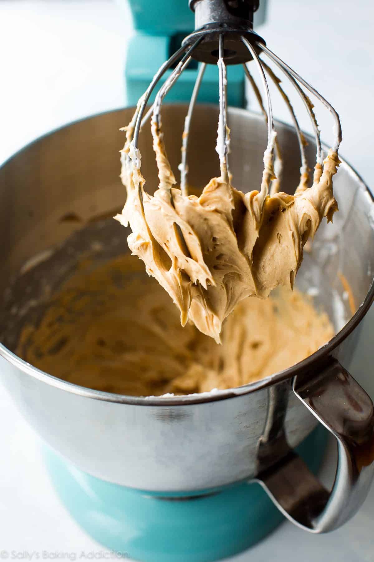 peanut butter meringue frosting in a stand mixer bowl with a whisk attachment