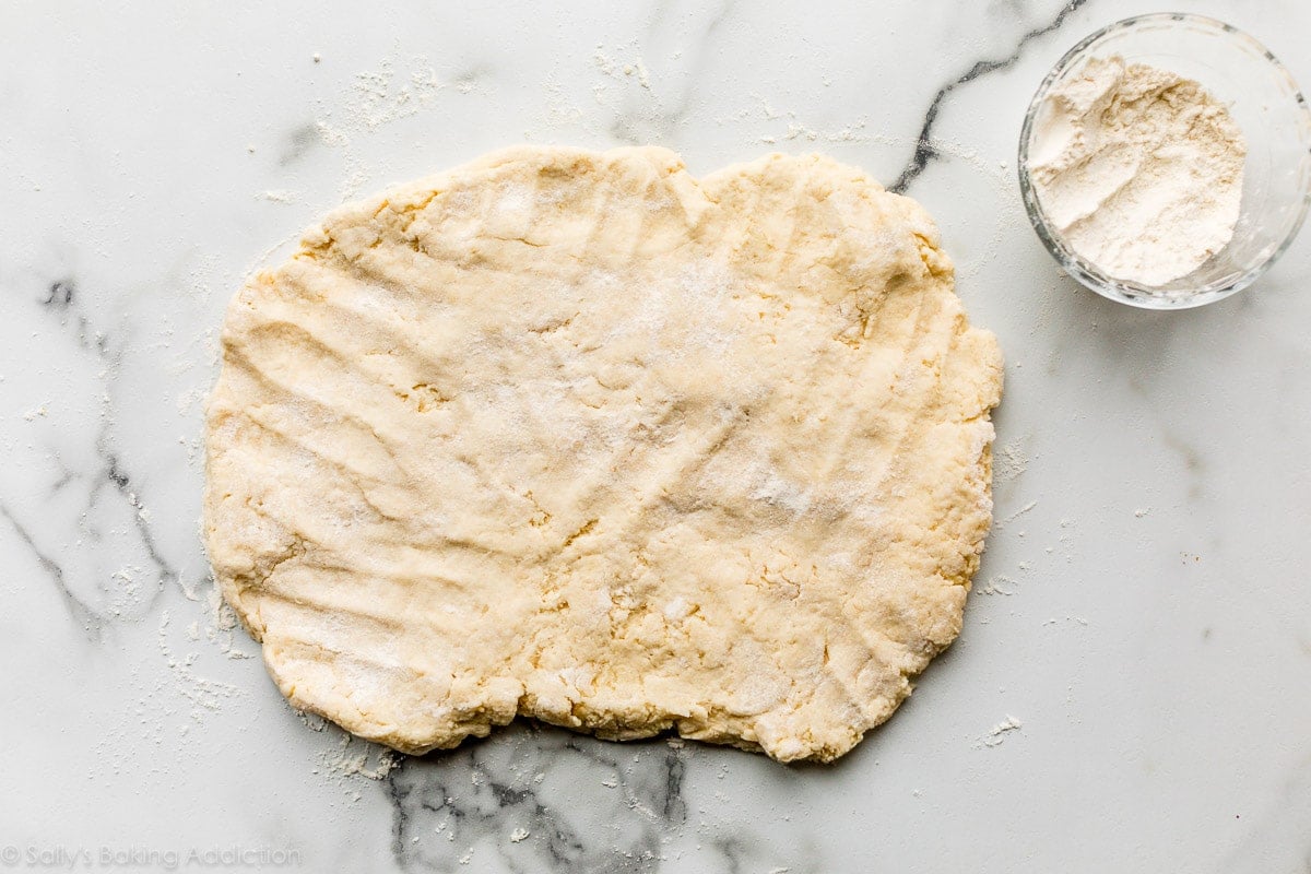flattened dough on marble counter