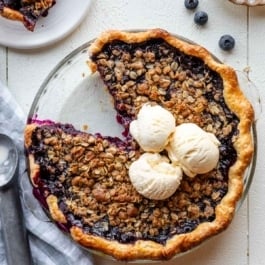 blueberry crumble pie with ice cream on top.