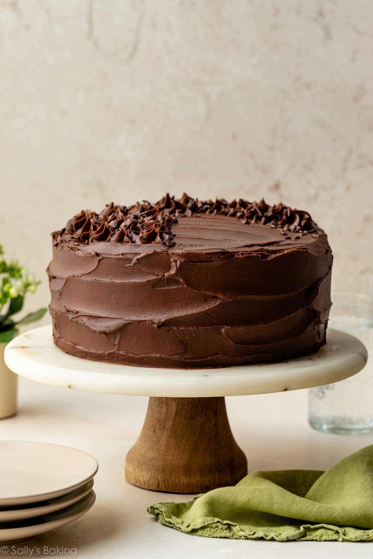 chocolate zucchini cake on marble and wood cake stand.