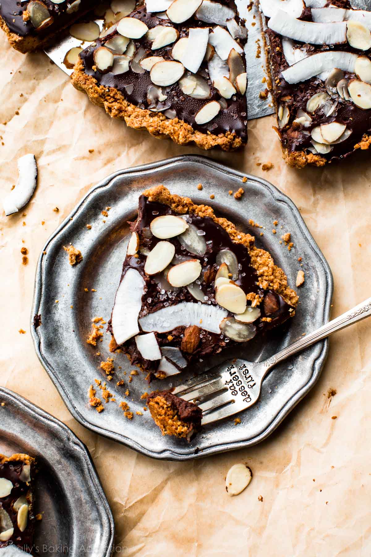 slice of chocolate coconut almond tart on a silver plate with a fork