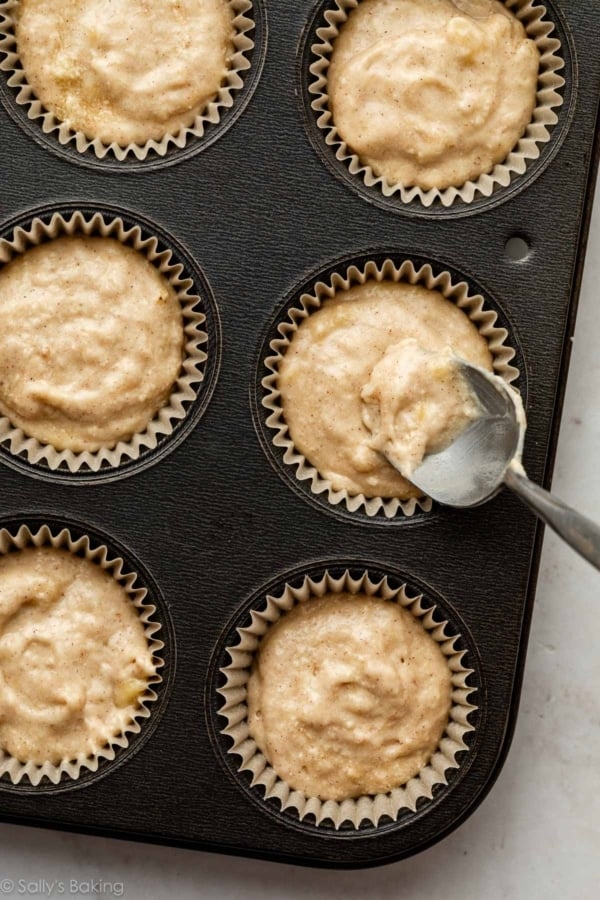 spooning batter into cupcake liner.
