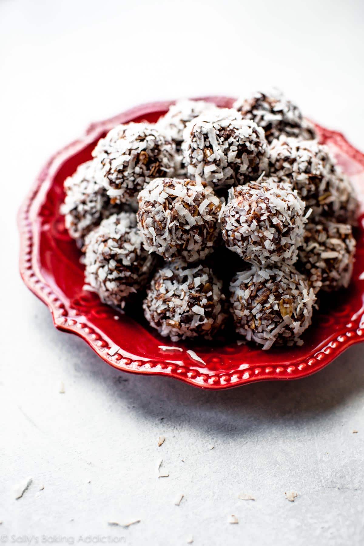 stack of no-bake chocolate coconut snowballs on a red plate