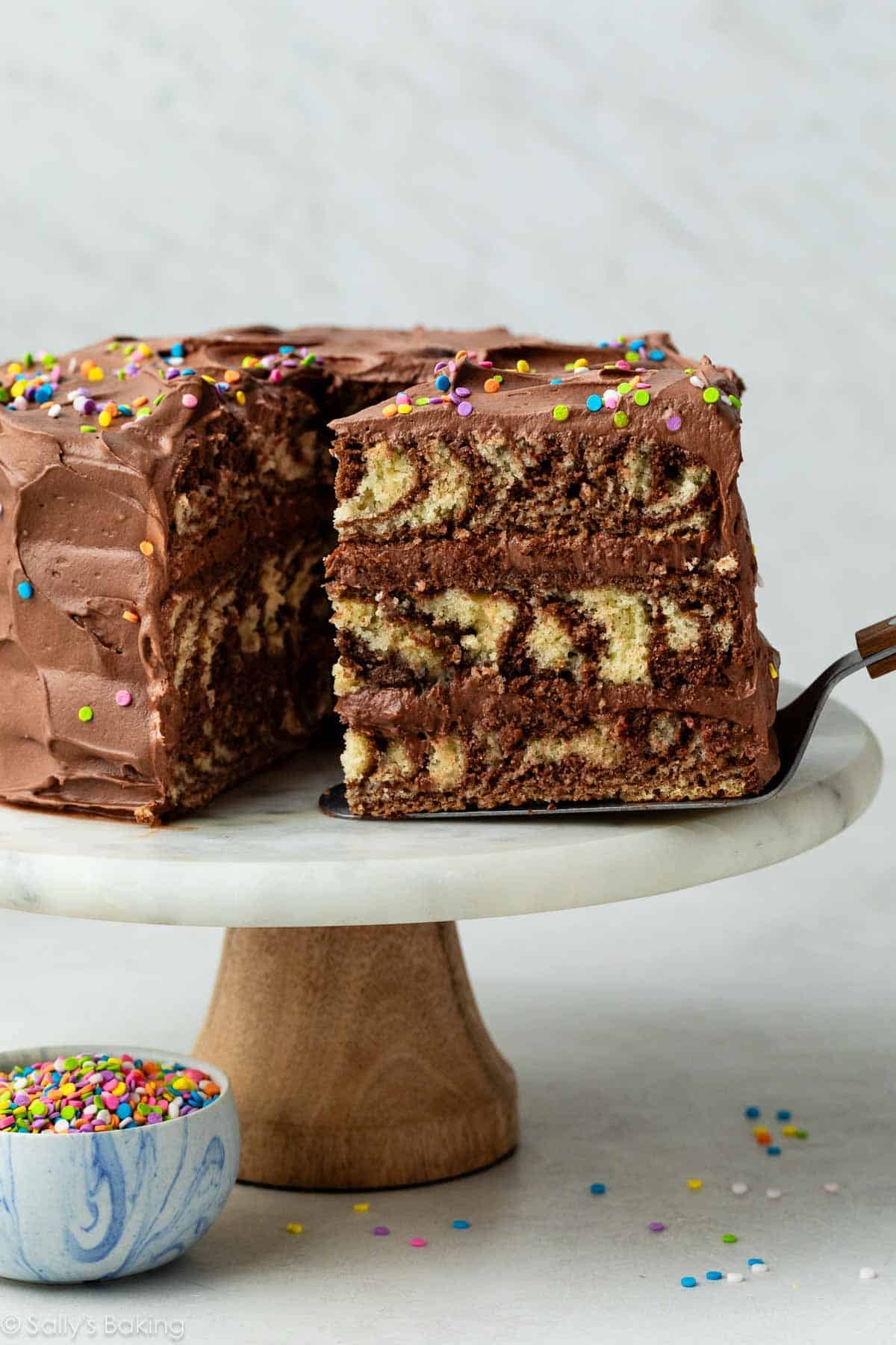 slice of zebra cake being removed from cake stand.