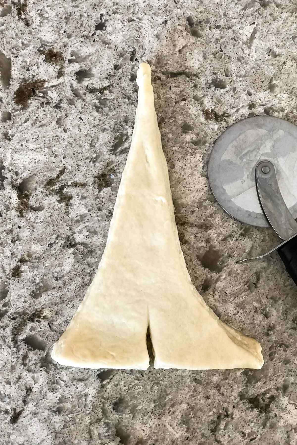 dough cut for one croissant before rolling