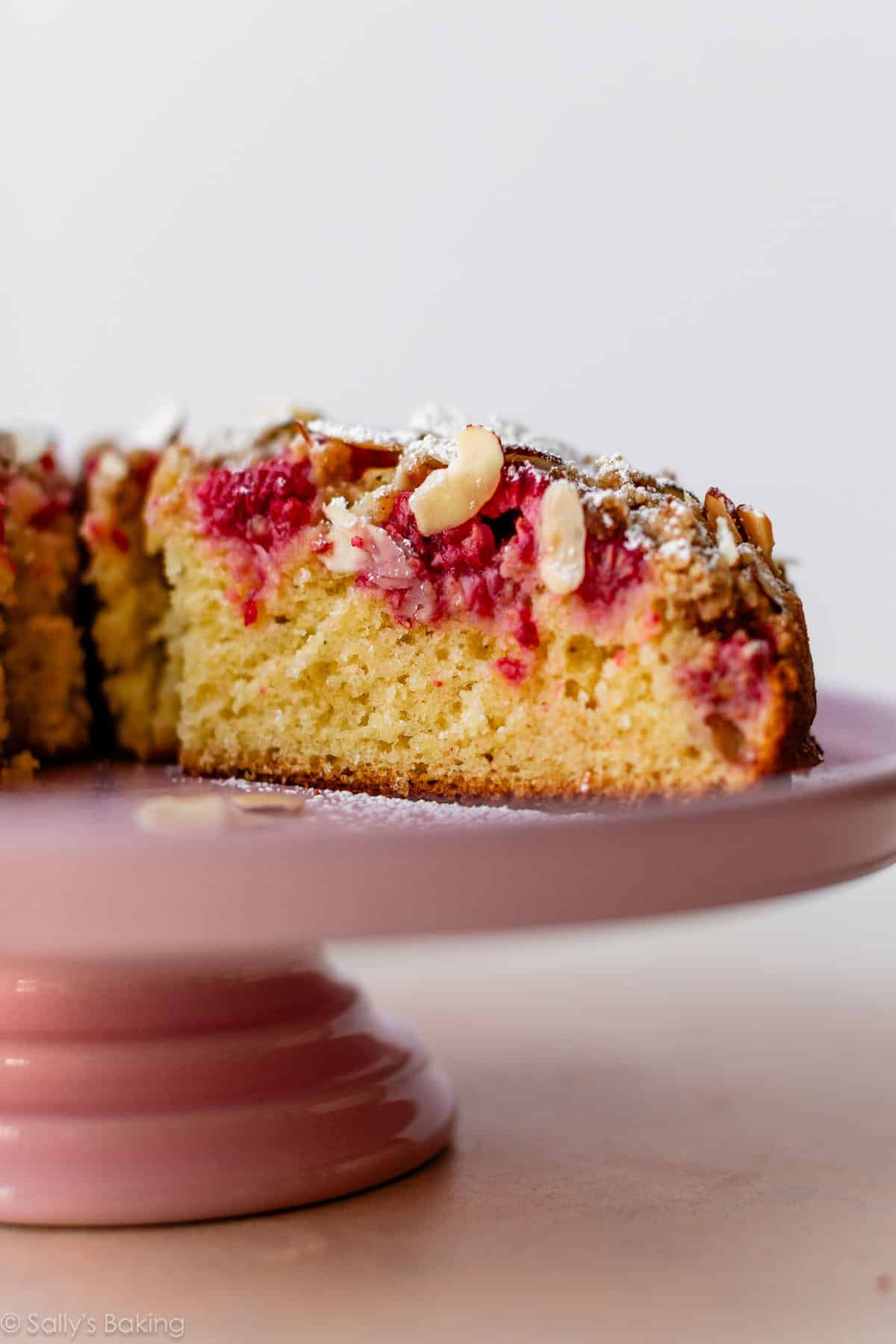 raspberry crumb cake on pink cake stand.