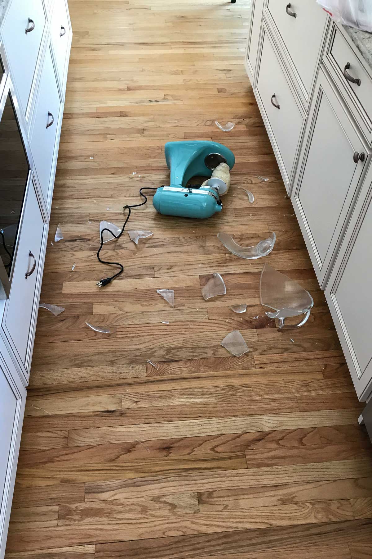 kitchenaid stand mixer on the floor with a broken bowl