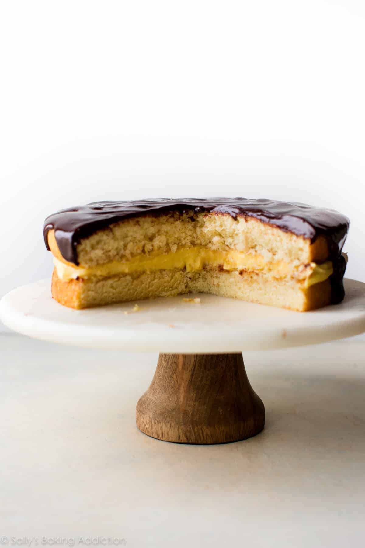 Boston cream pie on a wood and marble cake stand