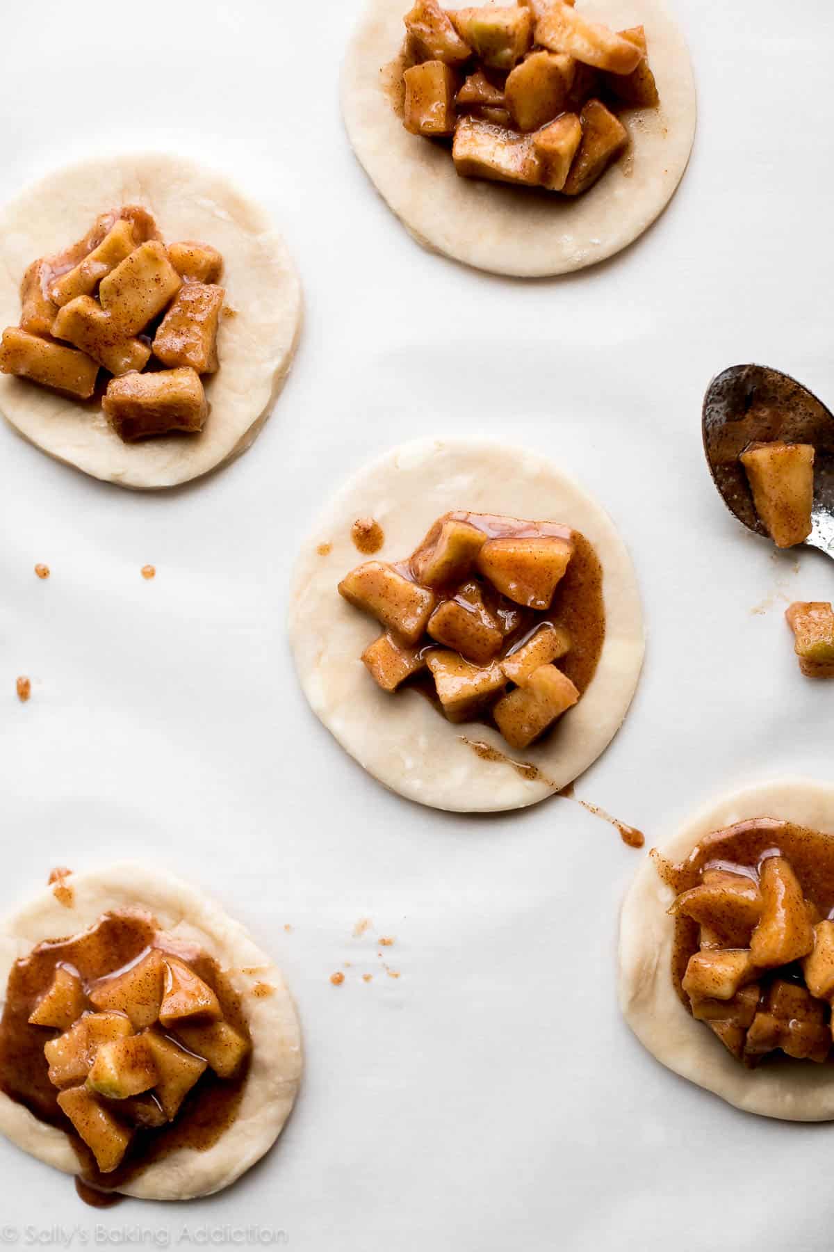 apple pie filling on circles of pie dough for hand pies