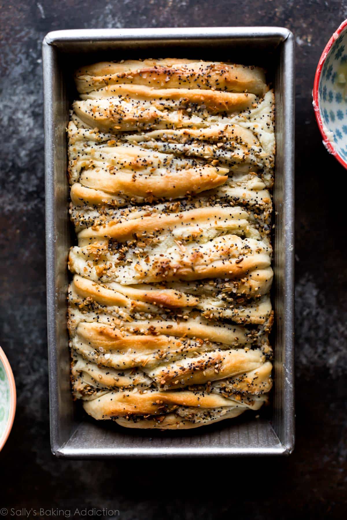 overhead image of baked everything bagel bread in a loaf pan