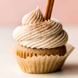 chai latte cupcake with a cinnamon stick garnish