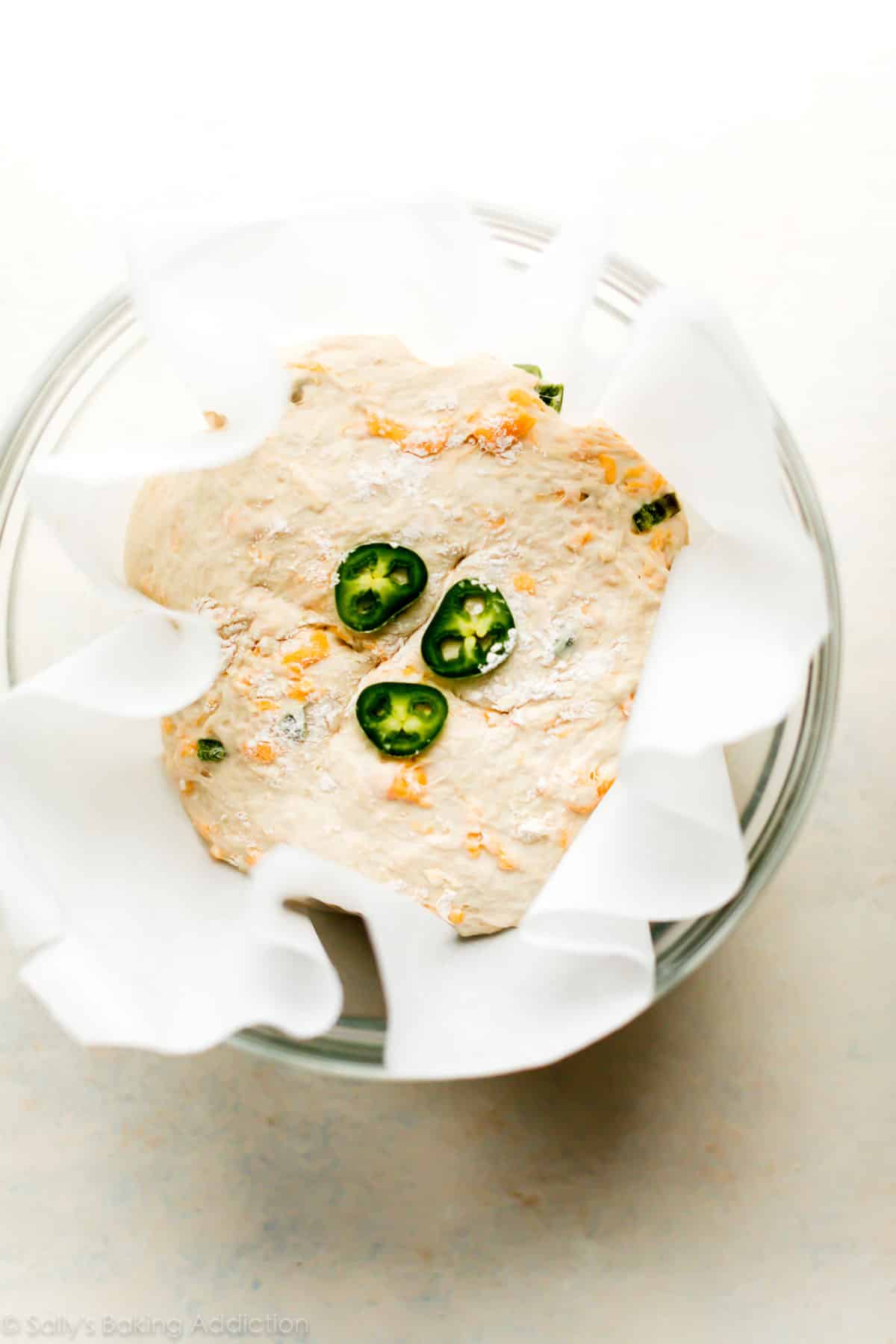 jalapeno cheddar bread dough in a glass bowl