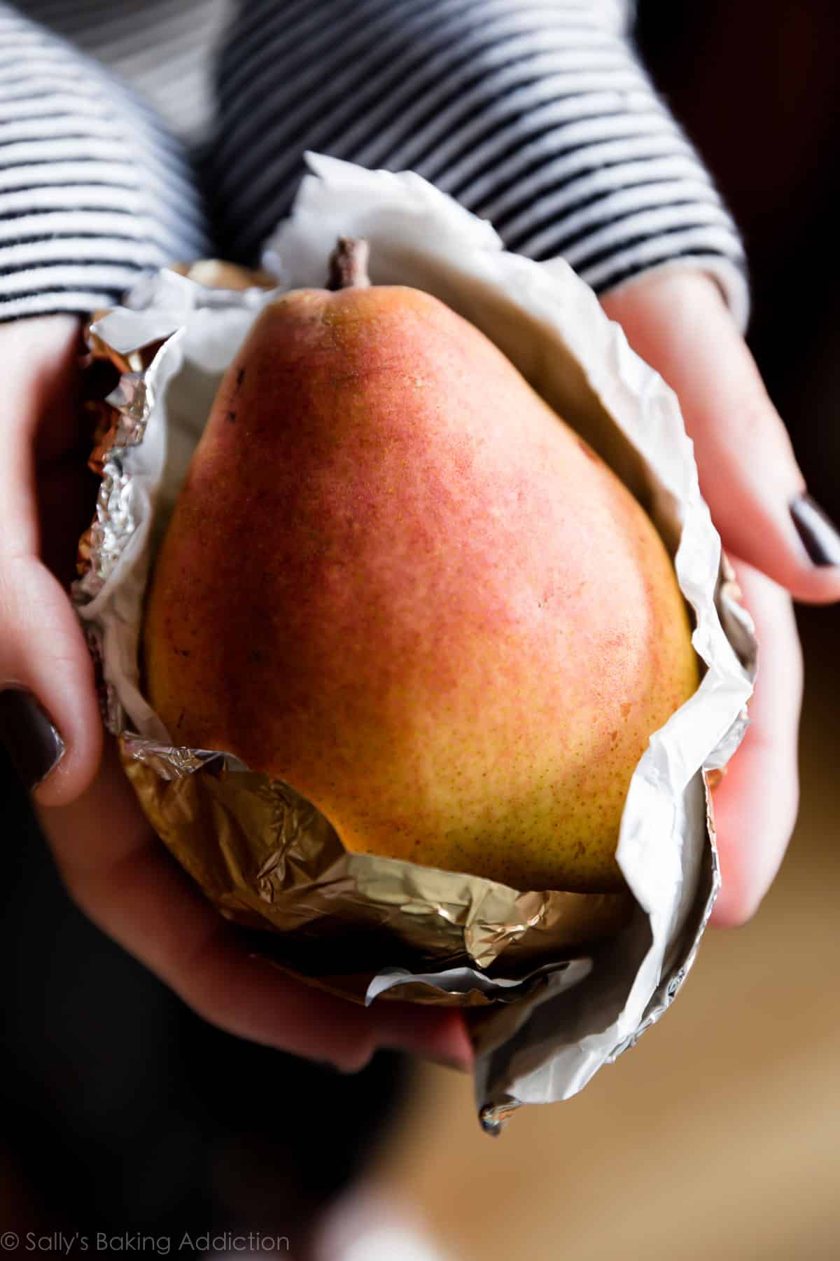 hands holding a Harry & David Royal Riviera Pear