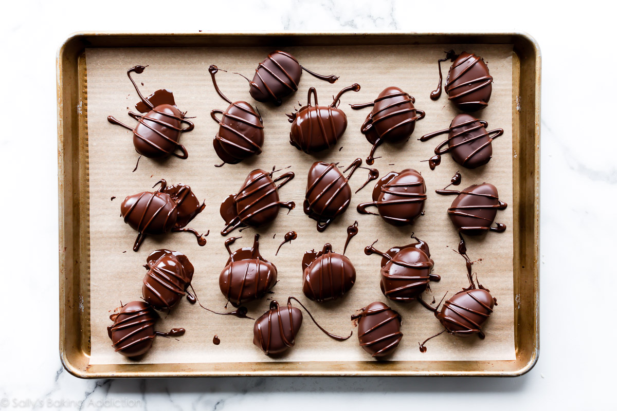 Chocolate covered buttercream Easter eggs on parchment lined baking sheet