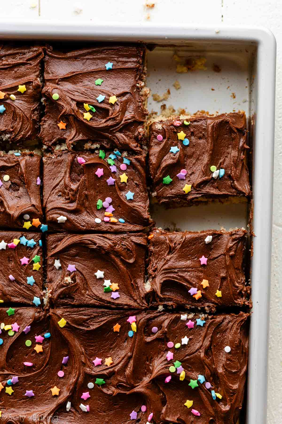 9x13-inch pan of yellow cake with chocolate frosting and sprinkles.