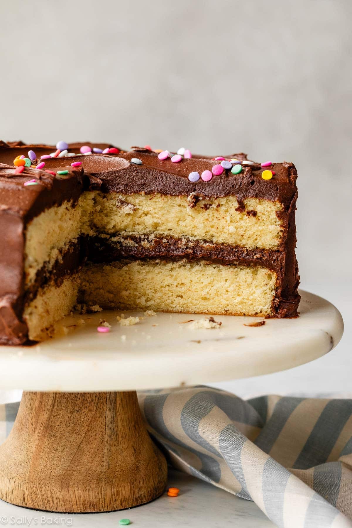yellow cake with chocolate frosting on cake stand.