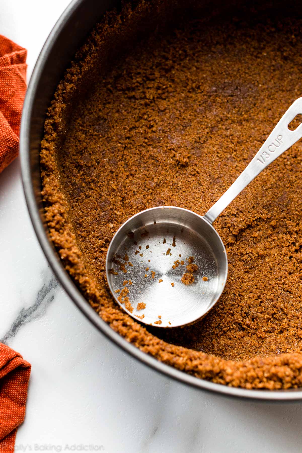 pressing a gingersnap crust into a springform pan