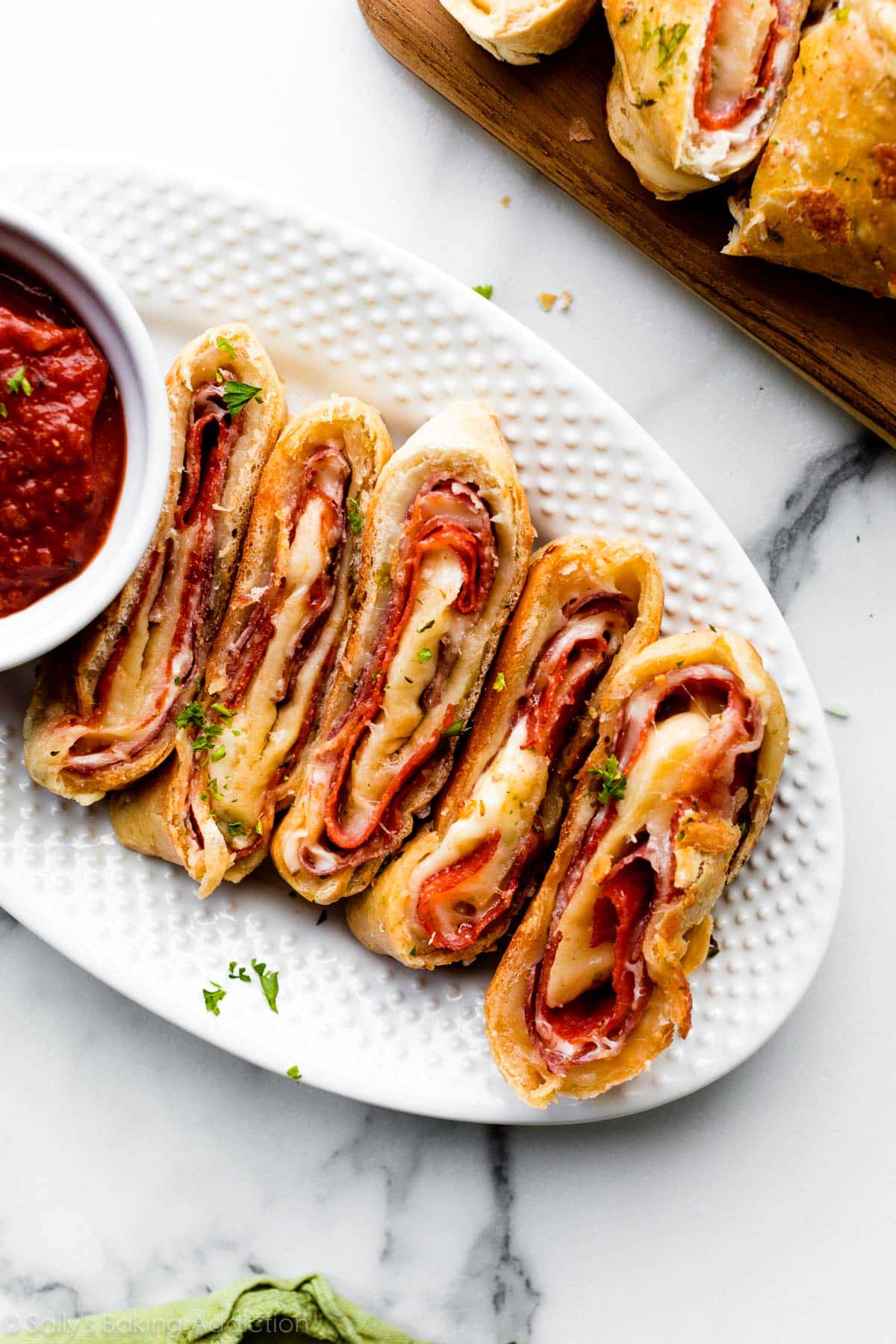 pepperoni and salami stromboli slices on white plate