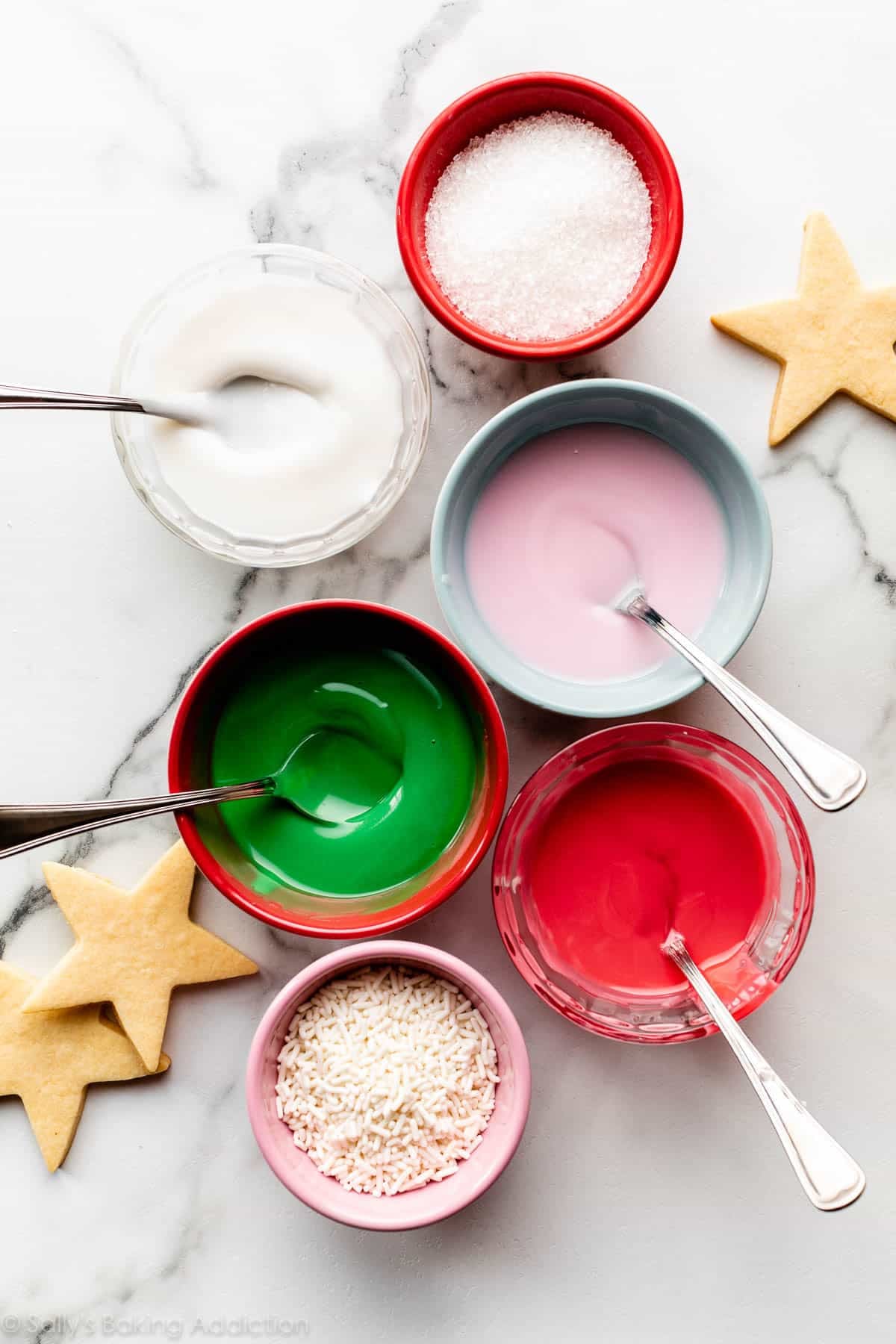bowls of colored icing and white sprinkles