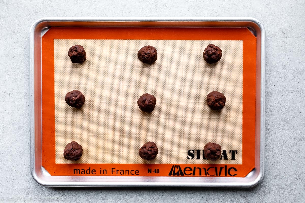 chocolate cookie dough balls on baking sheet lined with Silpat