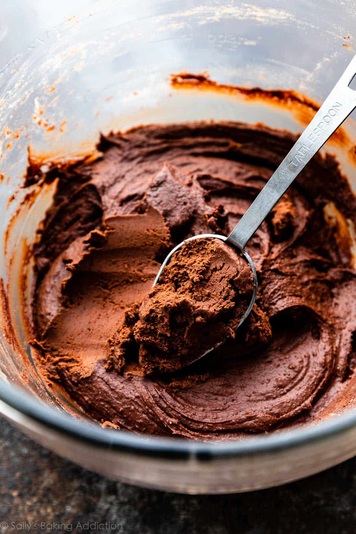 brownie cookie dough with 1.5 Tablespoon measuring spoon scooping dough out