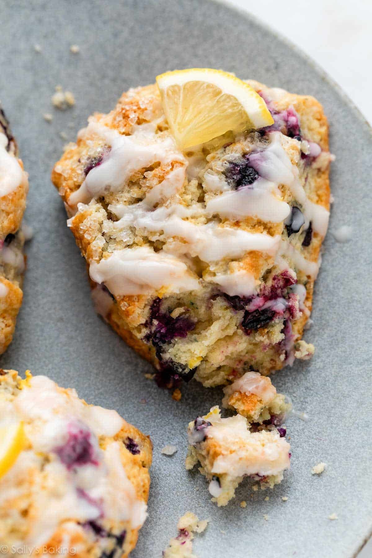 close-up of glazed lemon blueberry scone with bite taken out.