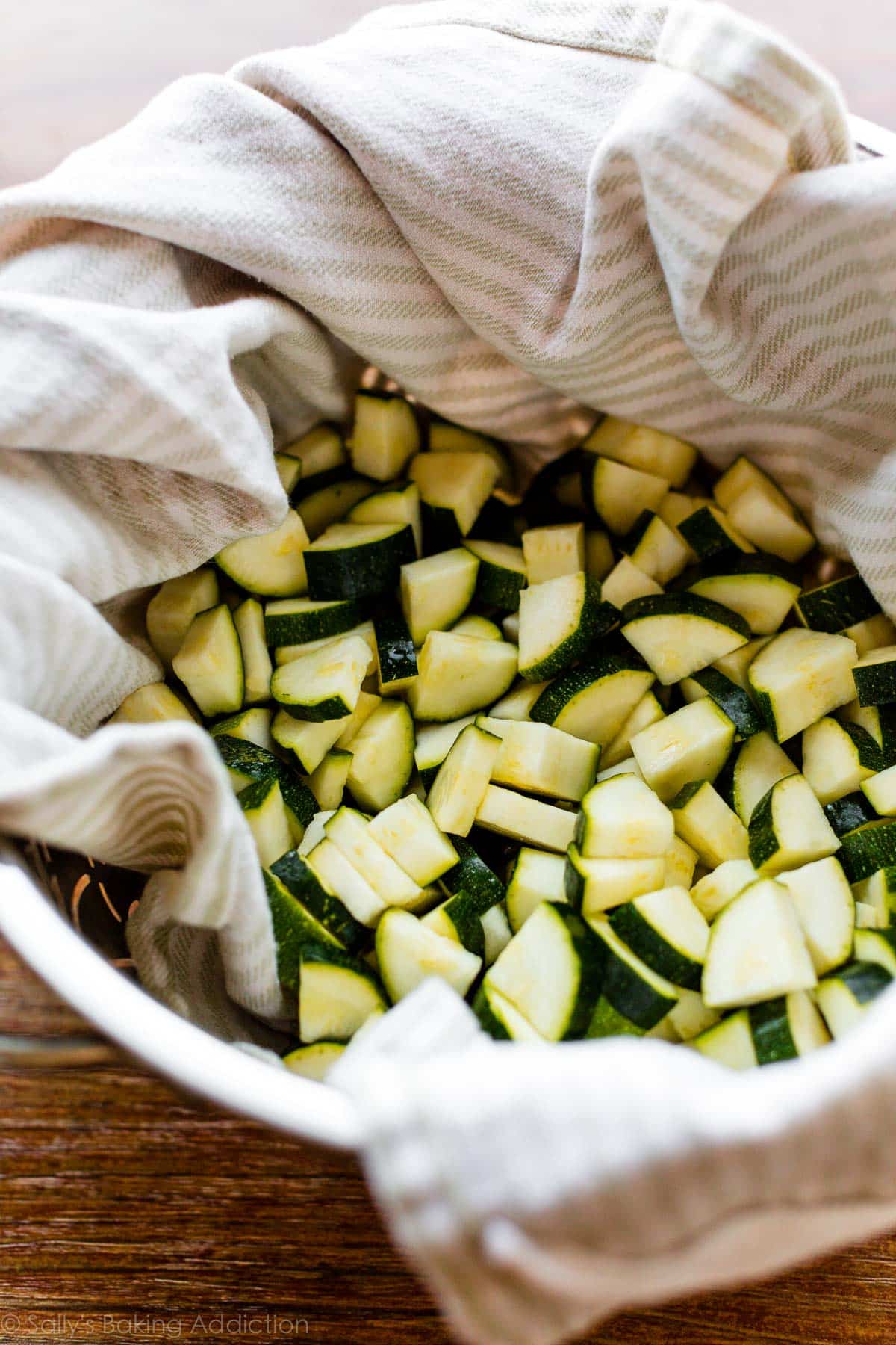 chopped zucchini in towel-lined colander