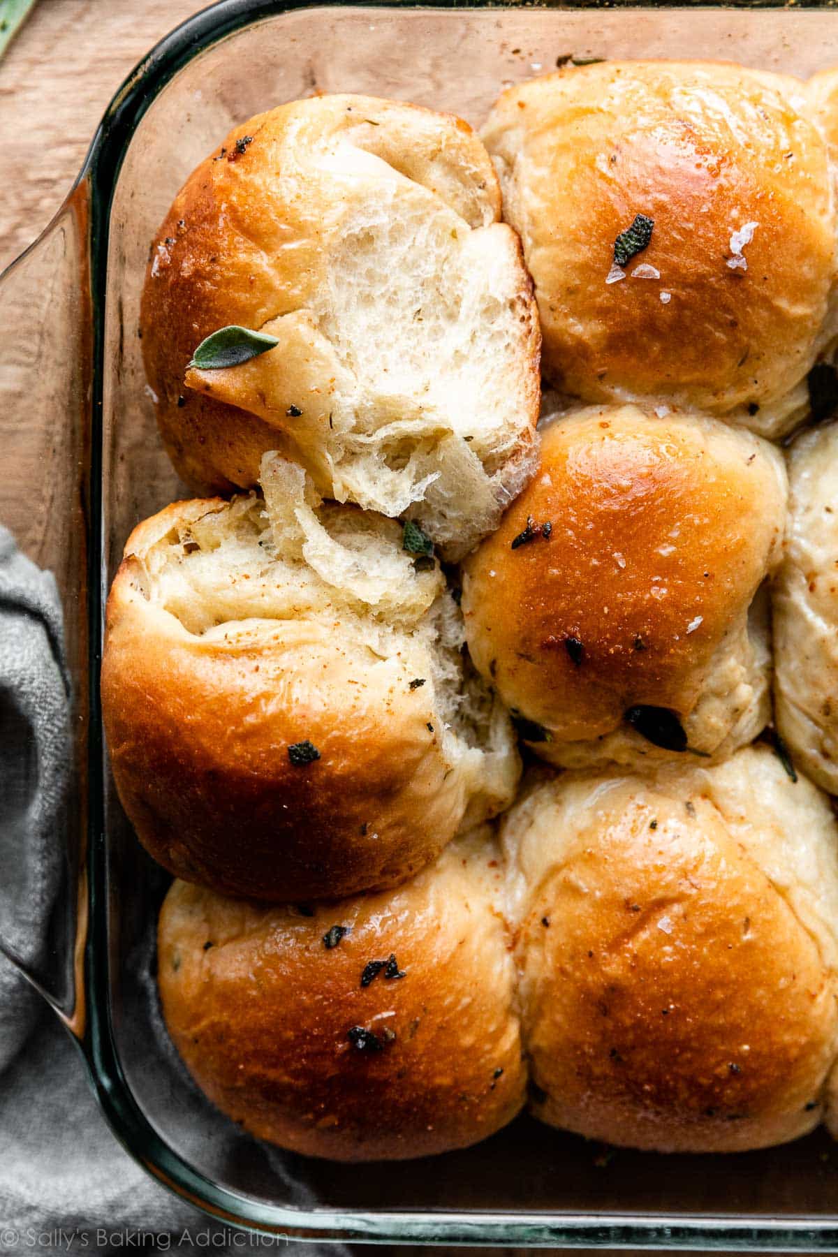 6 sage dinner rolls in glass baking pan.