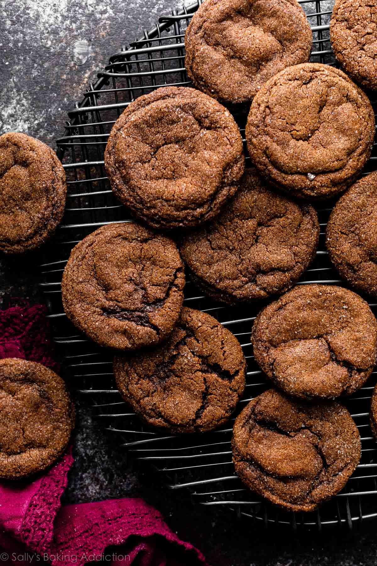 cocoa ginger crinkle cookies on black rounded wire cooling rack.