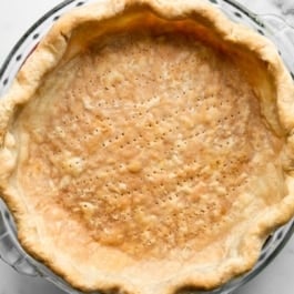 fully baked pie crust shell in glass pie dish.
