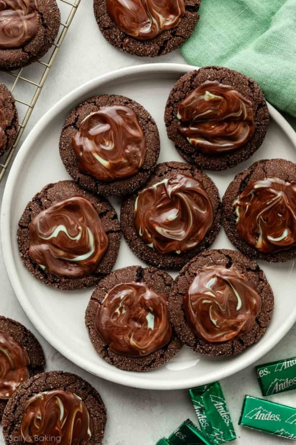 chocolate cookies with melted Andes chocolate mint spread on top on white plate.