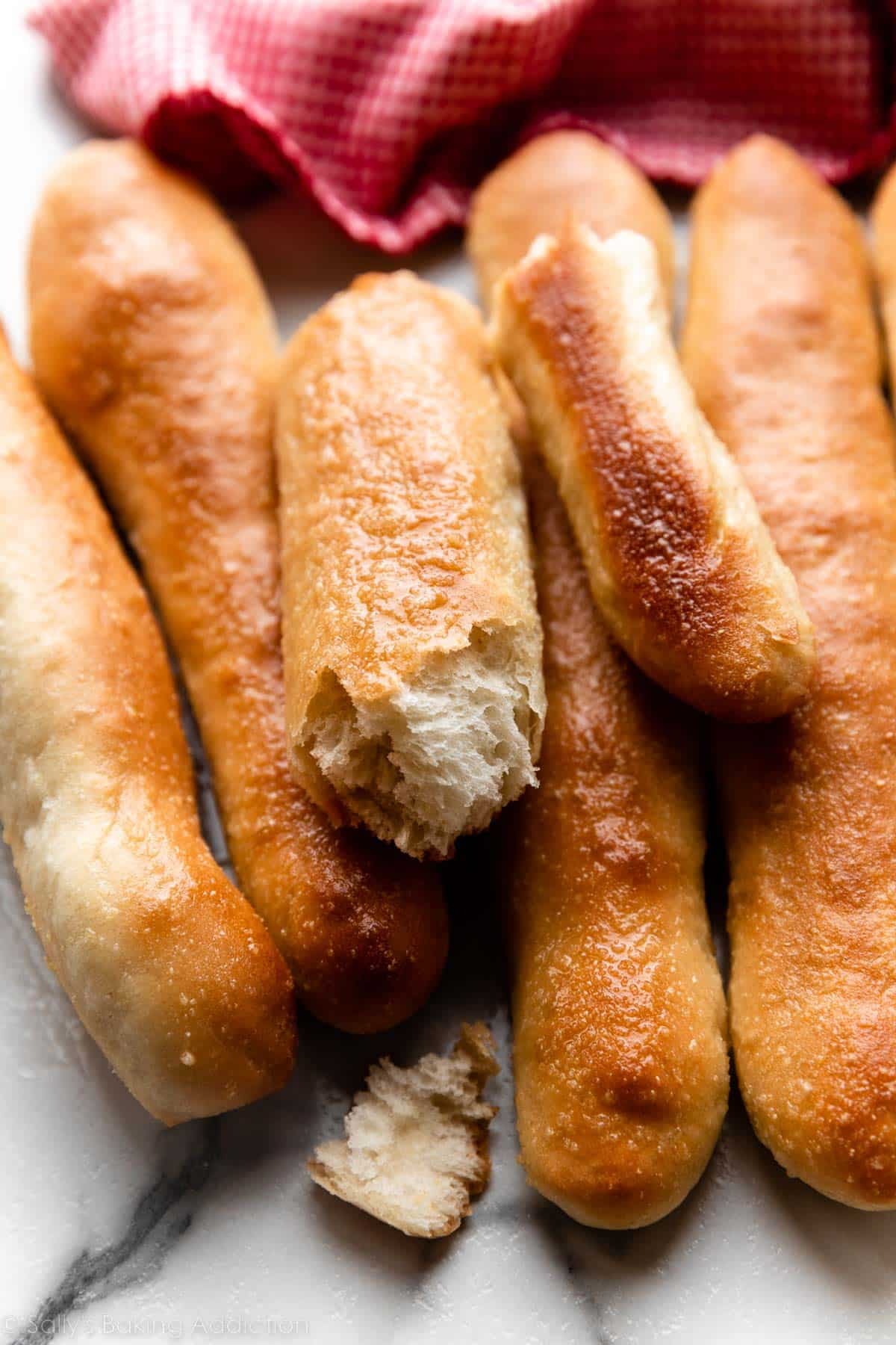 breadsticks on marble counter with red linen in background.