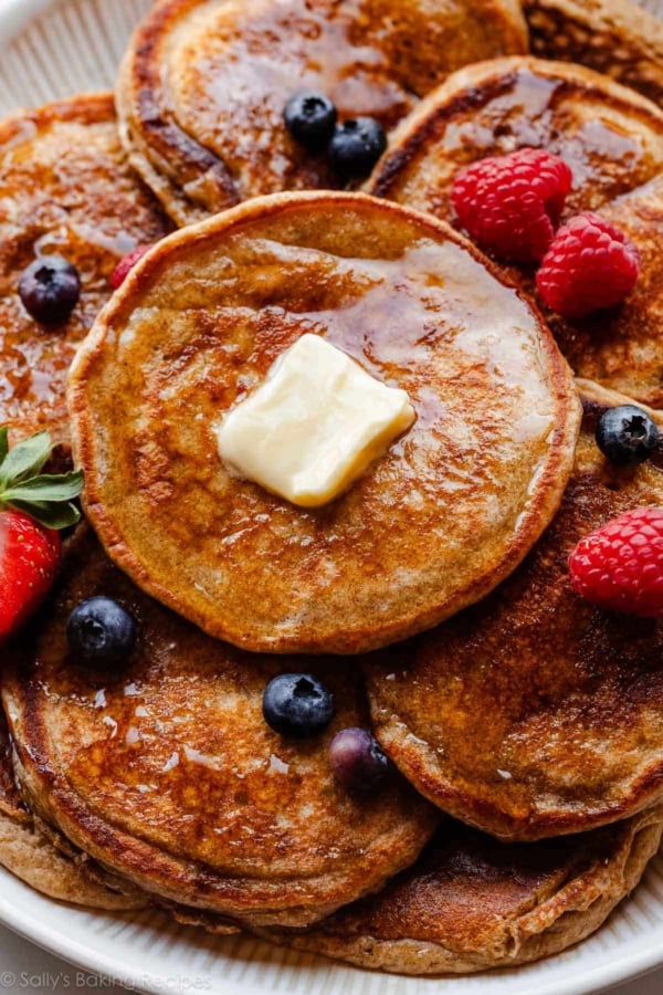 whole wheat pancakes with syrup, berries, and butter.