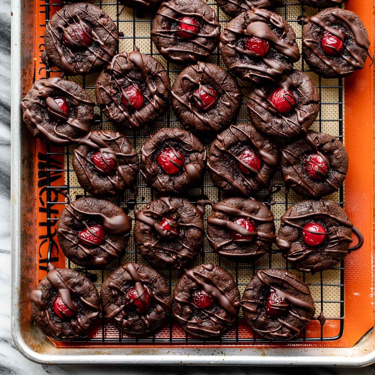 chocolate drizzled cookies with cherry in center.