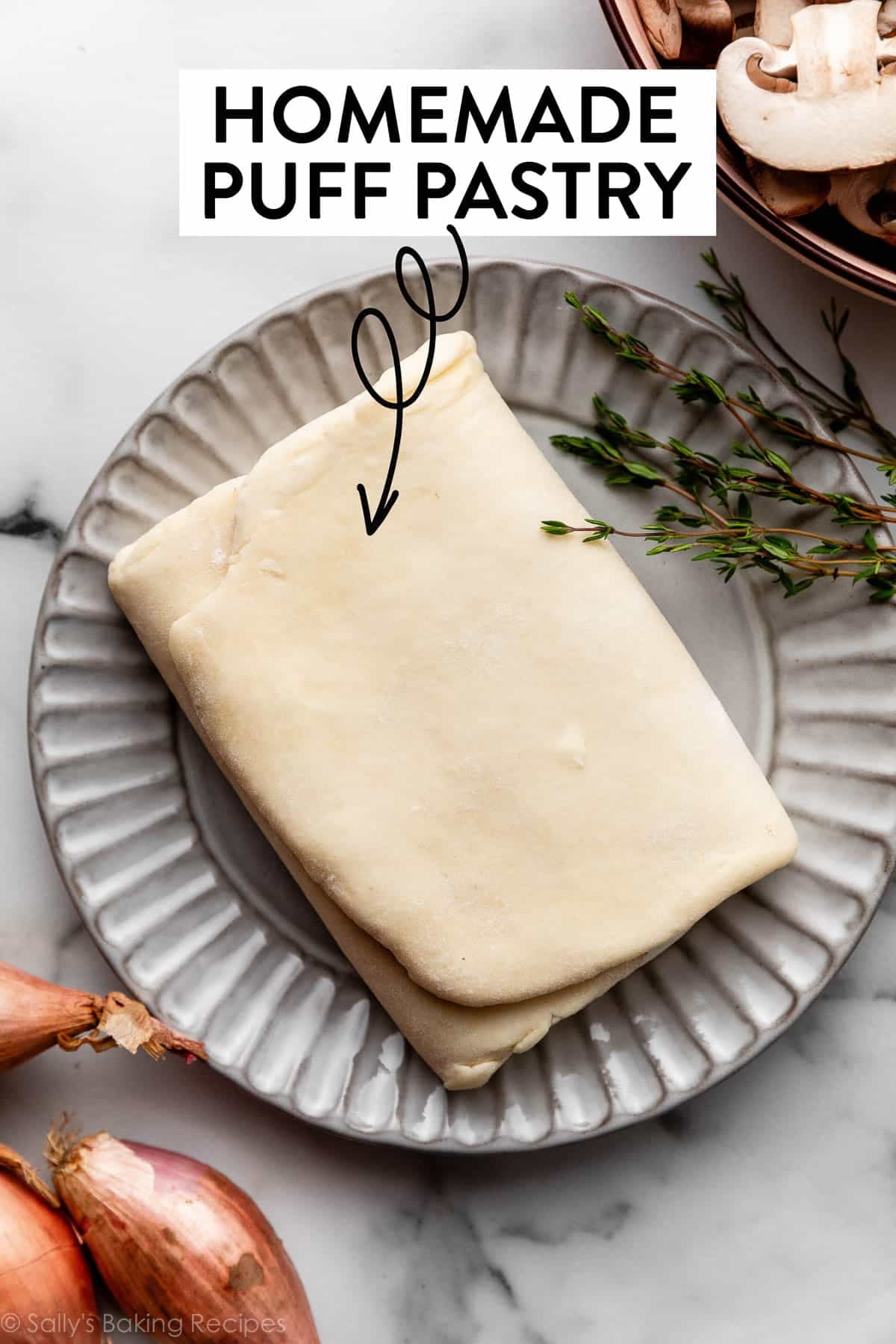 folded up dough on gray plate with graphic text overlay displaying the words homemade puff pastry.
