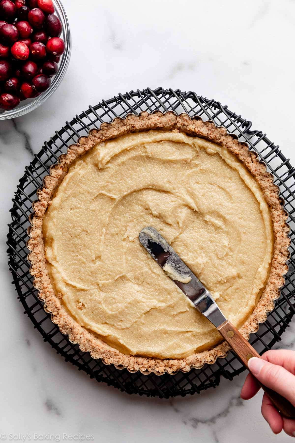spreading almond cream into tart crust.