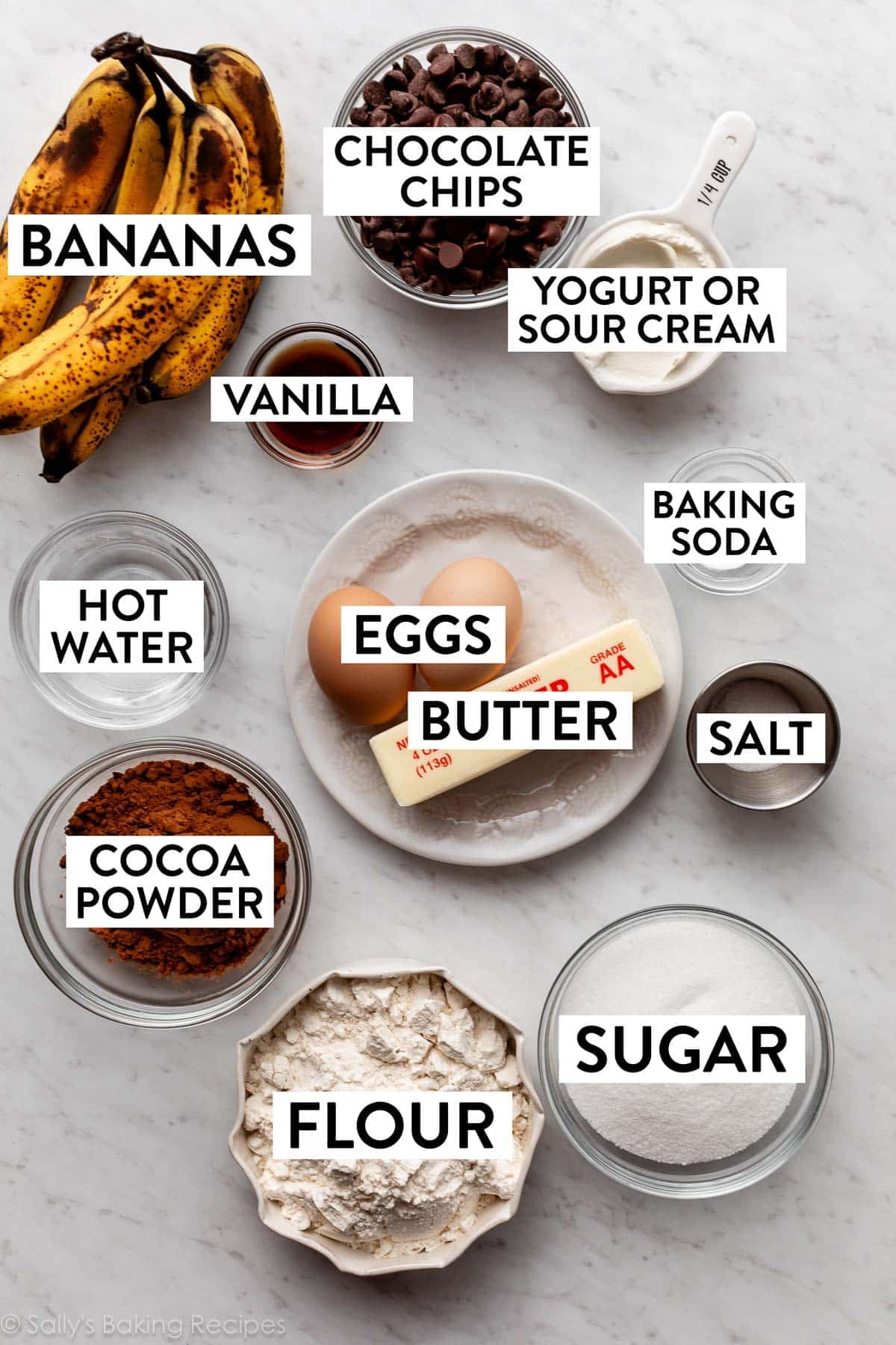 ingredients on counter including butter, eggs, sugar, flour, chocolate chips, and cocoa powder.