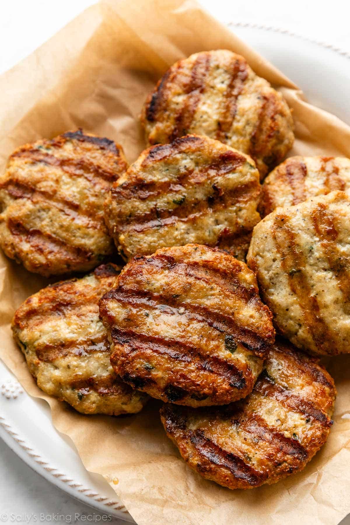 chicken burgers on parchment paper lined plate.