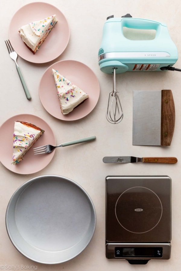 funfetti cake slices on pink plates with cake tools including a round cake pan, handheld mixer, and food scale.