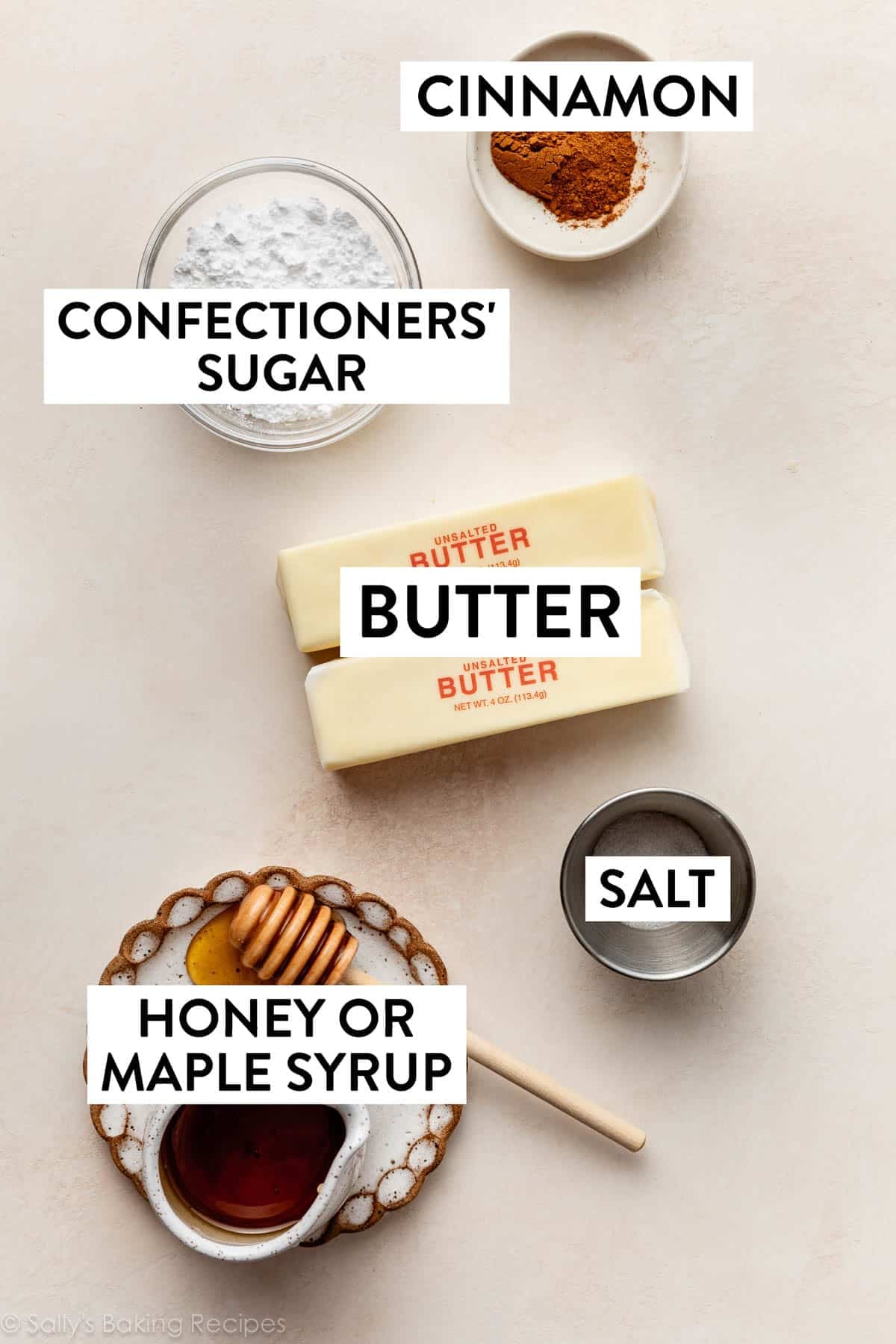 ingredients on peach surface including confectioners' sugar, salt, honey, and butter.