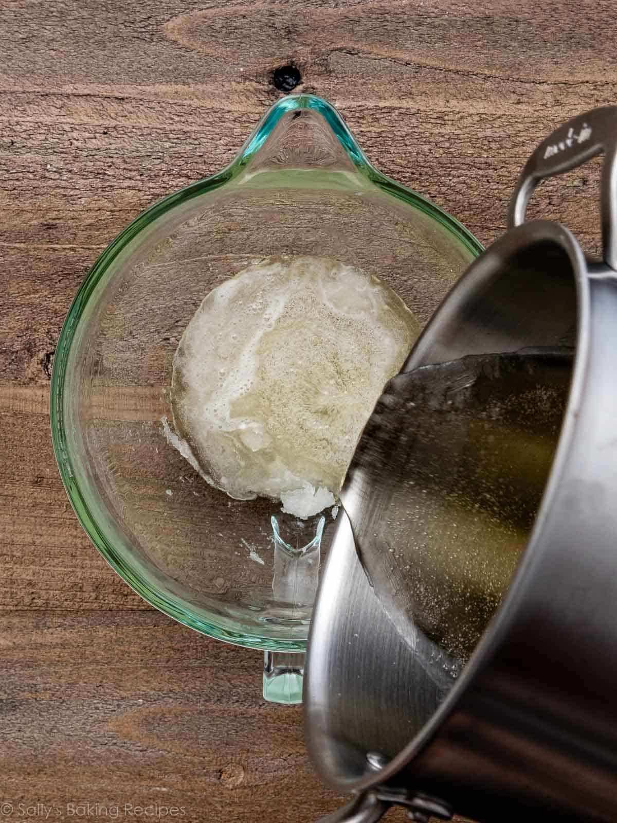 pouring syrup over gelatin mixture in glass bowl.