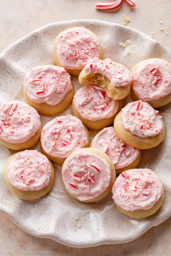 peppermint meltaway cookies with pink frosting and crushed candy canes on top.