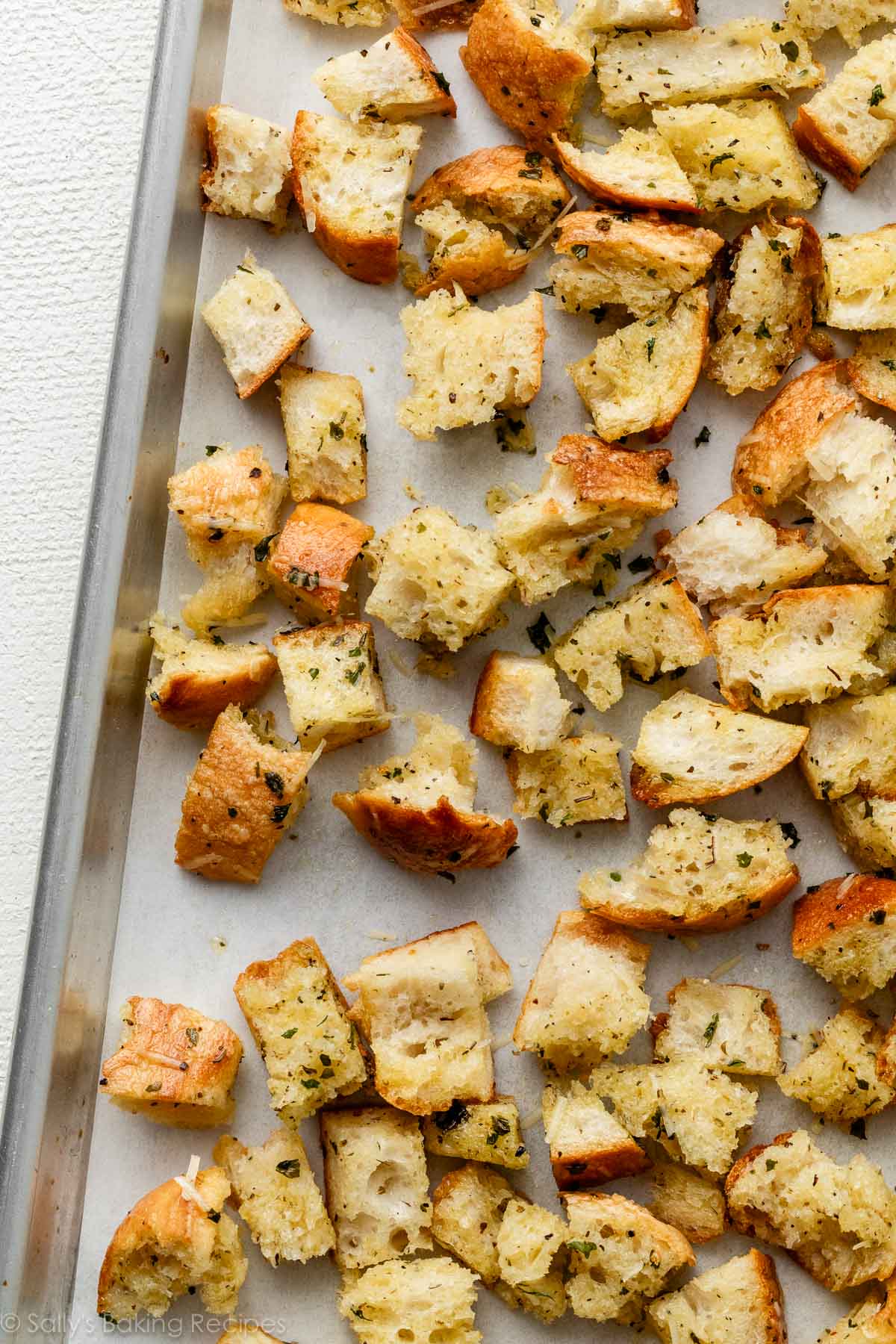 cubes of olive oil and herb-soaked bread on baking sheet.
