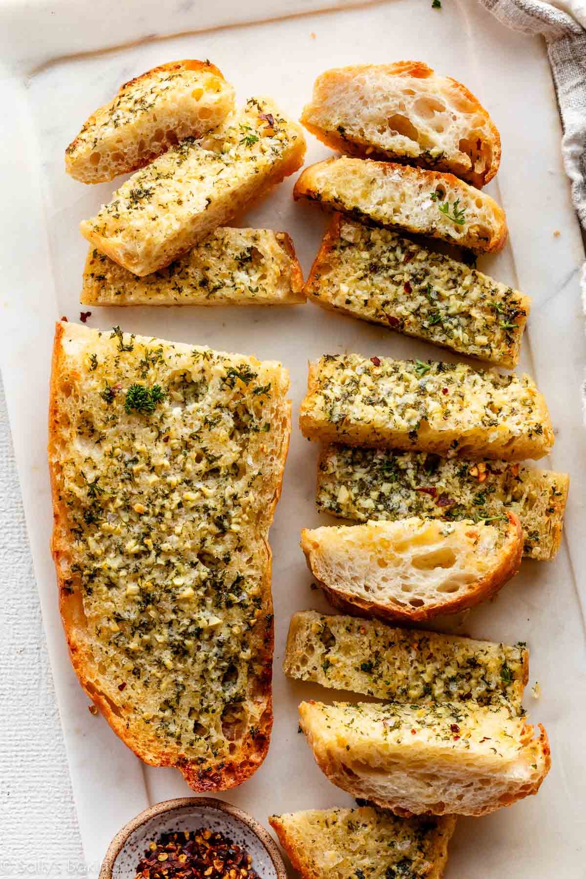 garlic bread cut into slices on marble board.