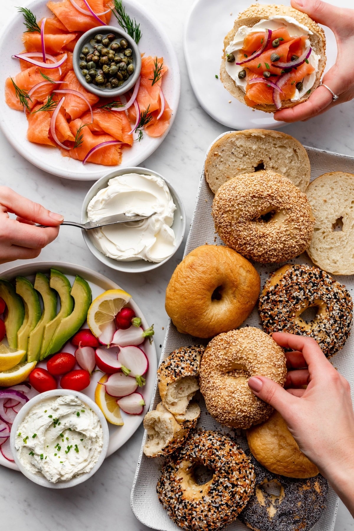 Platter of bagels with salmon, avocado, radishes, and cream cheese.