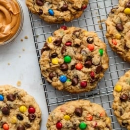 monster cookies with M&Ms on cooling rack.