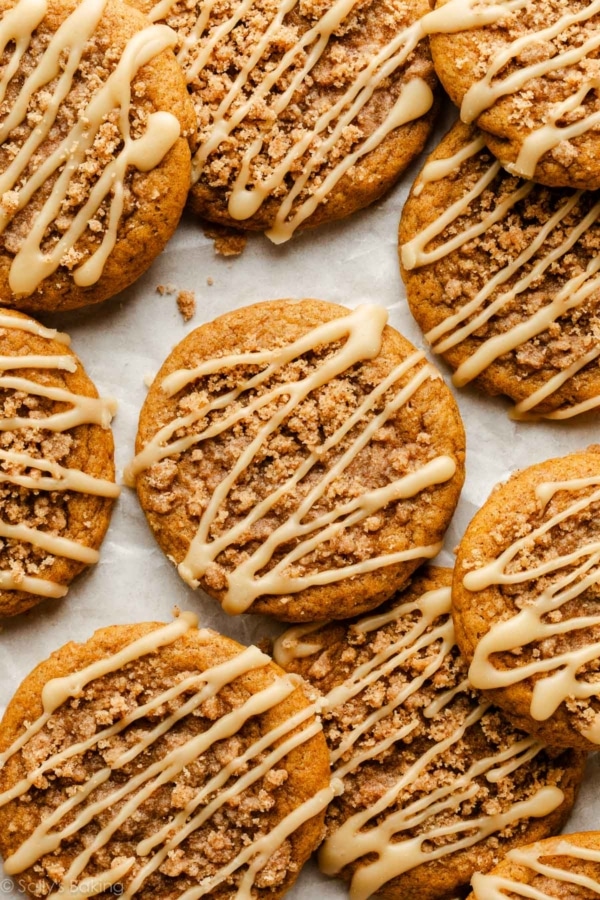 pumpkin crumb cake cookies with maple icing on parchment paper.